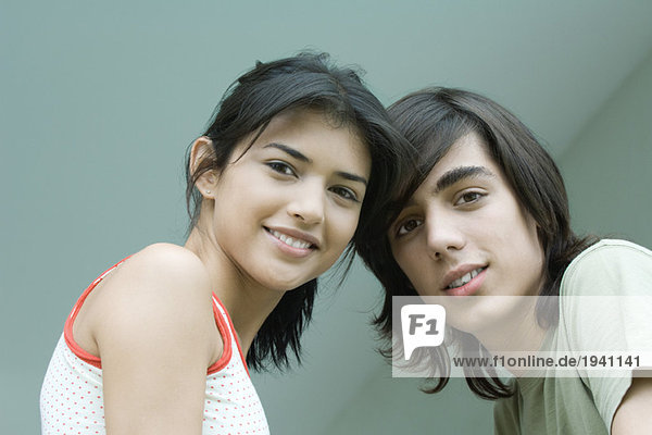 Young male and female friends  head and shoulders  looking at camera