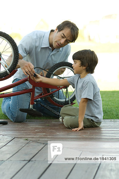 Vater und Sohn reparieren Fahrrad zusammen