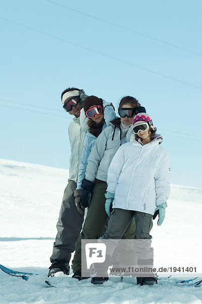 Group of snowboarders posing in snow  full length