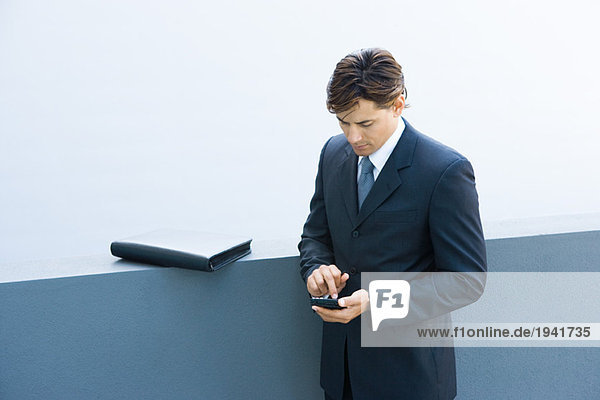 Young businessman using palmtop  looking down  high angle view