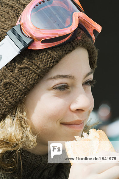 Girl wearing ski gear  eating sandwich  close-up