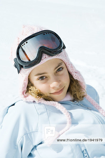 Preteen girl wearing ski gear  smiling at camera  portrait