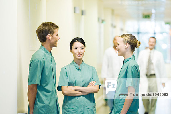 Drei Mediziner im Krankenhausflur im Gespräch