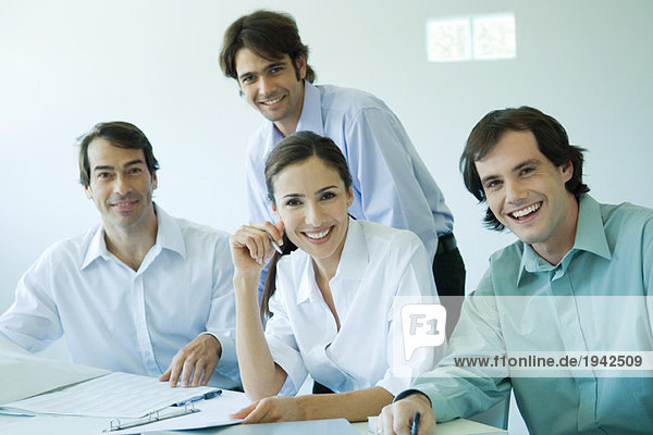 Four business associates smiling at camera  waist up