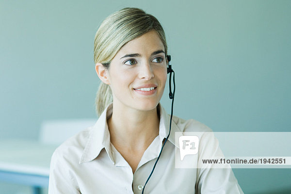 Young businesswoman wearing headset  smiling  head and shoulders