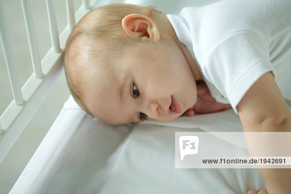 Baby in crib  lying on side  head and shoulders