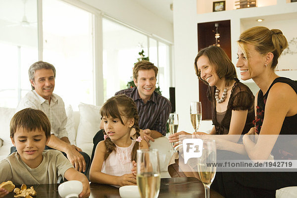 Vier Erwachsene trinken Champagner  beobachten Kinder  lächeln