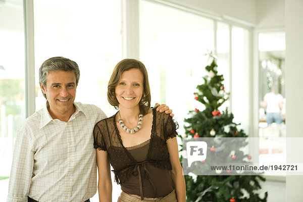 Erwachsenes Paar  Portrait vor dem Weihnachtsbaum
