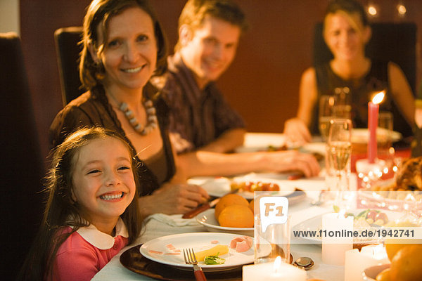 Family eating festive dinner  looking toward camera  smiling