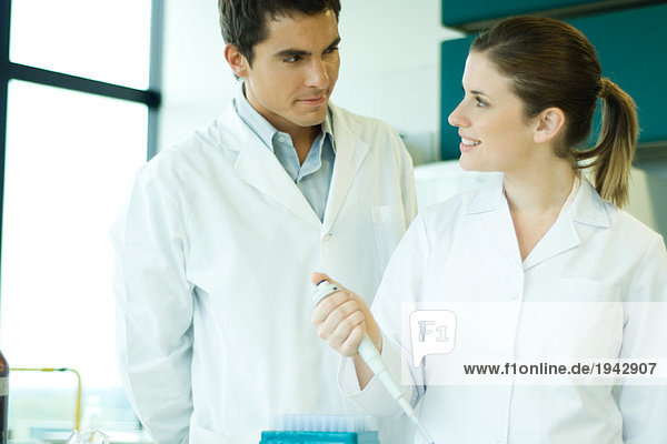 Young female lab worker smiling at supervisor
