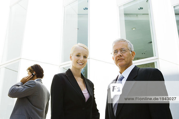 Mature businessman and young businesswoman  low angle view
