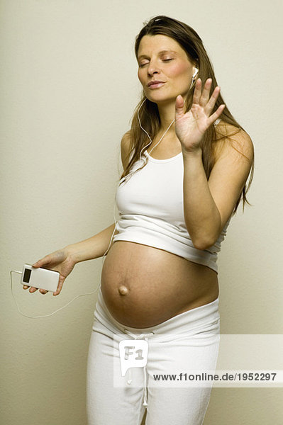 Schwangere Frau hört MP3-Player