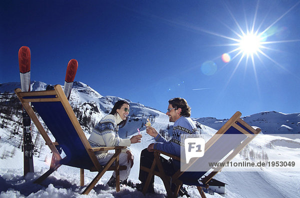Paar sitzend auf Liegestuhl in Schneerösterbrille  Seitenansicht