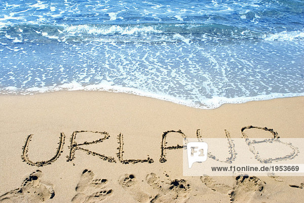 Wort (Urlaub) geschrieben in Sand am Strand