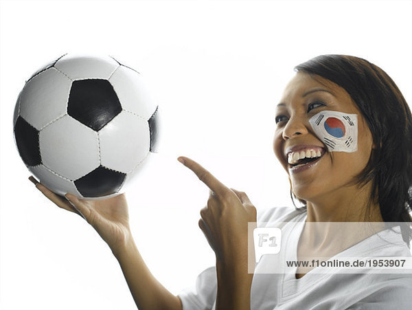 Frau mit koreanischer Flagge auf dem Gesicht  die auf Fußball zeigt  Nahaufnahme