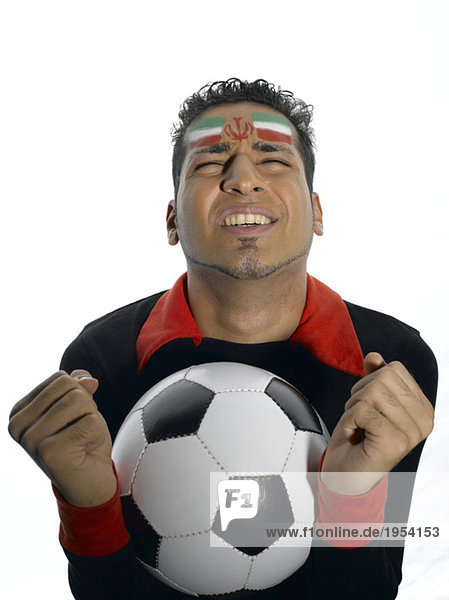 Mann mit iranischer Flagge auf Gesicht gemalt mit Fußball
