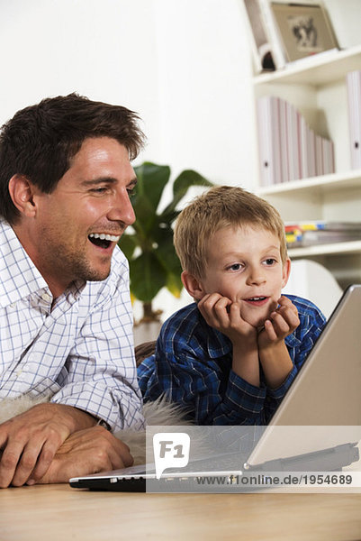 Vater und Sohn (6-7) mit Laptop