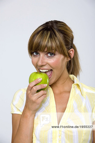 Junge Frau isst Apfel  Portrait  Nahaufnahme
