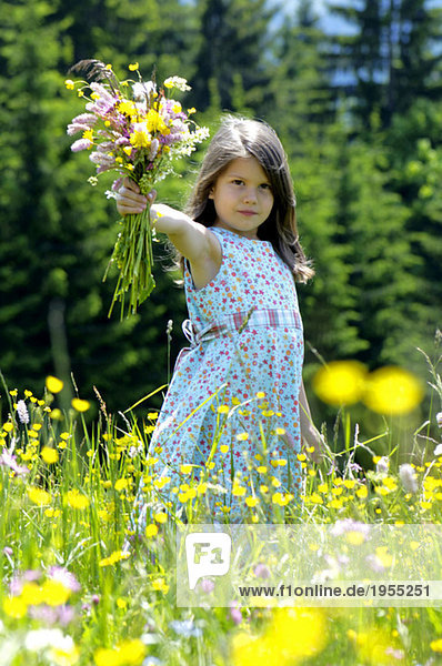 Mädchen mit Blumenstrauß auf der Sommerwiese