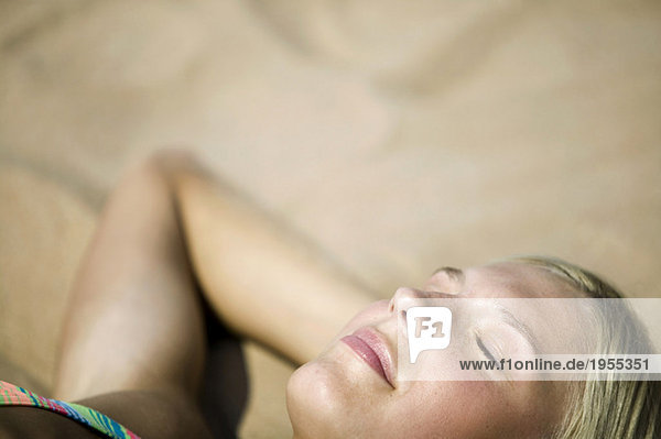 Frau entspannt am Strand  Augen geschlossen  (Fokus auf Vordergrund)