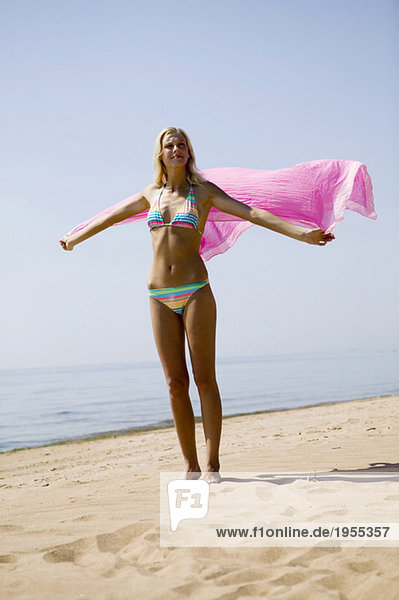 Junge Frau am Strand mit Schal