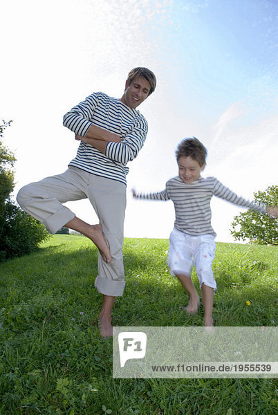 Vater und Sohn (4-7) im Park  Junge springend