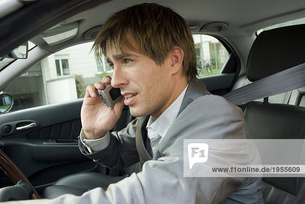 Businessman using mobile phone in car  side view  close-up