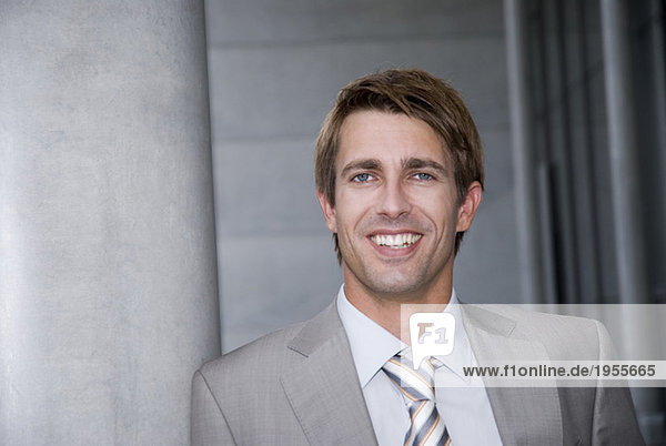 Businessman leaning on wall  close-up  portrait