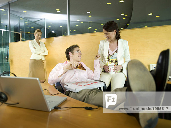 Couple having lunch in office  woman watching