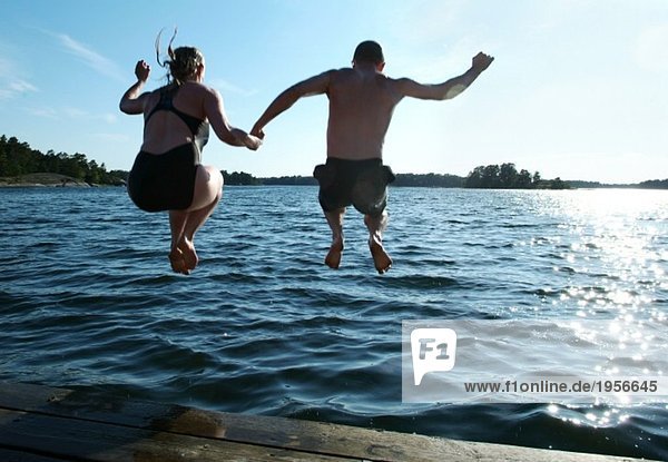 Paar springt ins Wasser