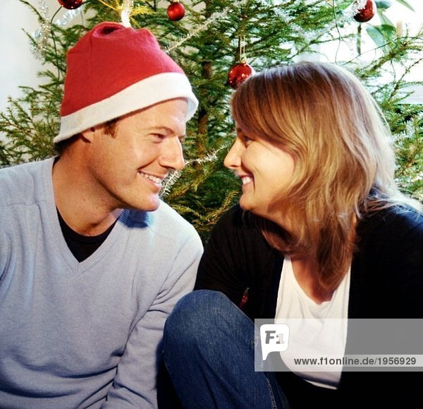 Mann und Frau vor dem Weihnachtsbaum