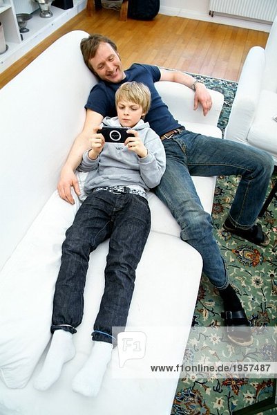 Father and son lying in couch