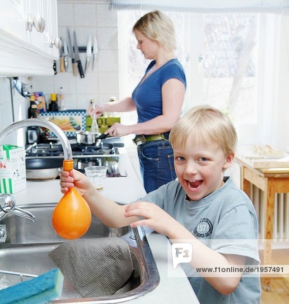 Boy filling a balloon with water