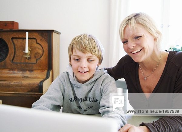 Mutter und Sohn benutzen den Computer gemeinsam