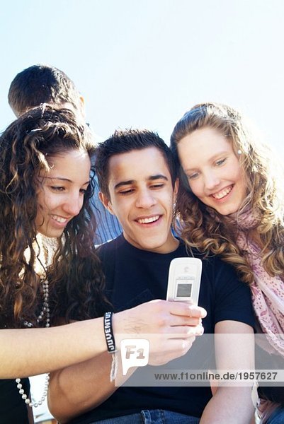 Happy teenagers looking at text message