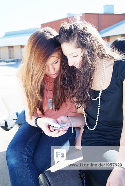 Two girls looking at a mobile