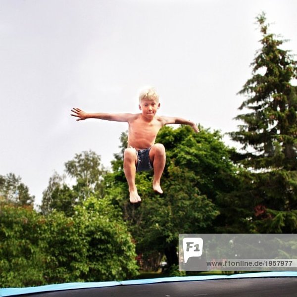 Junge  der auf einem Trampolin springt.