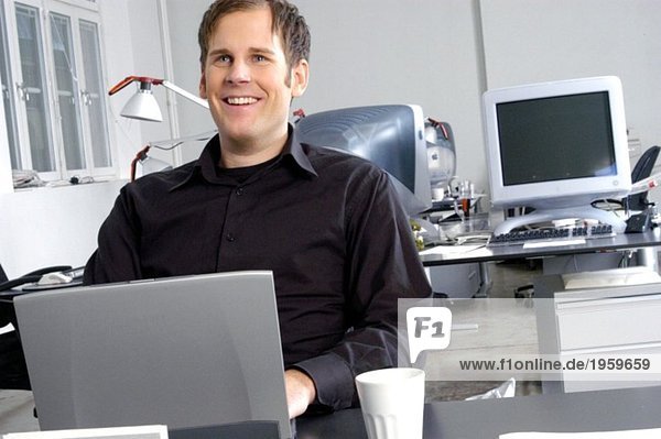 Man laughs in grey office envirorment