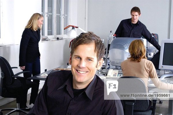 Mann lächelt im Büroumfeld