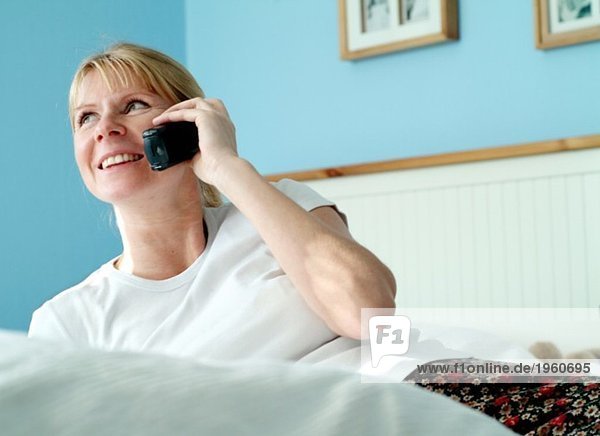 Woman talking on the phone in bed