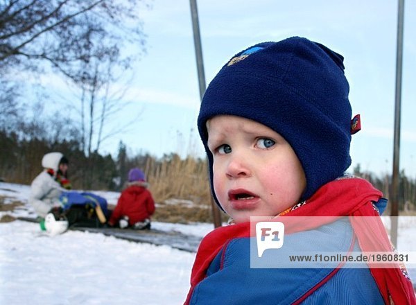 Upset boy in winter clothes