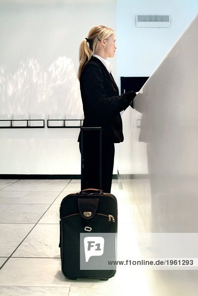 Frau beim Einchecken in ein Hotel