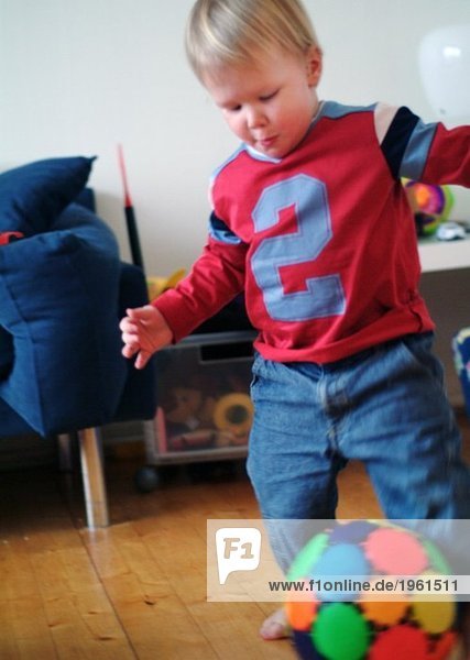 Junge spielt Fußball im Wohnzimmer
