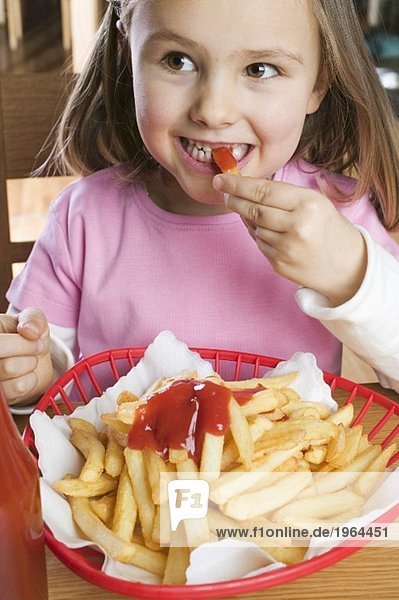 Girl eating chips with ketchup