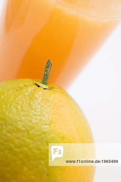 Glas Orangensaft und Orange (Ausschnitt)