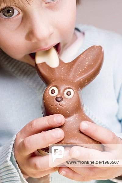 Kind beisst in Schokoladenosterhasen