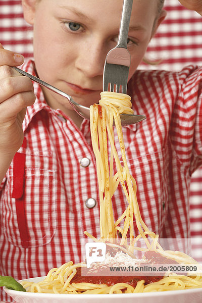 Mädchen dreht Spaghetti auf Gabel