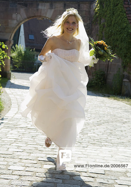 Hochzeit  Braut rennt über Kopfsteinpflaster