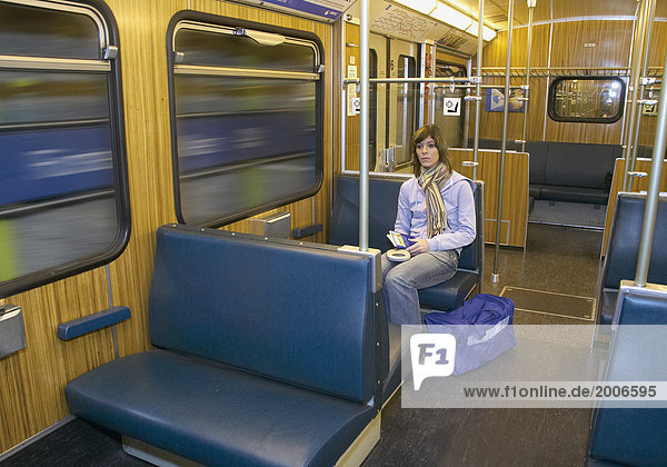 Junge Frau sitzt allein in U-Bahn