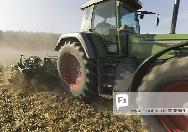 Traktor beim Pflügen auf Acker